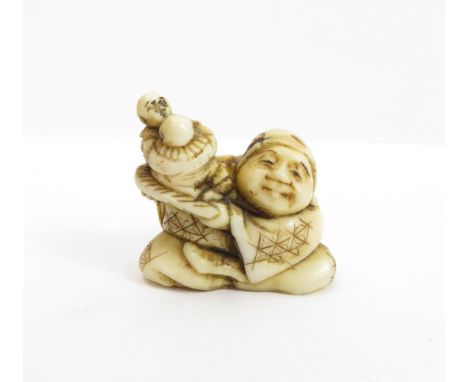 A 19th century Japanese ivory netsuke of man, holding a smaller carving of a children
