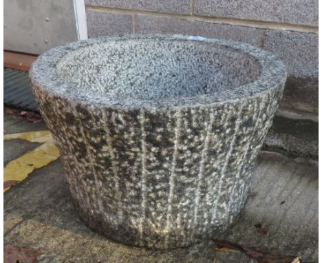 A circular textured granite planter, 31cm high 48cm diameter