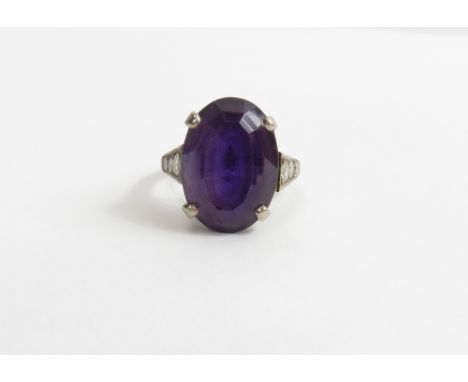 An amethyst and diamond dress ring, the white mount stamped '18ct', the oval cut amethyst measuring approximately 15.8 mm by 