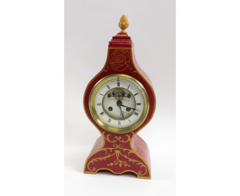 A red painted mantel clock, with white enamel dial and Roman numerals, 41cm high