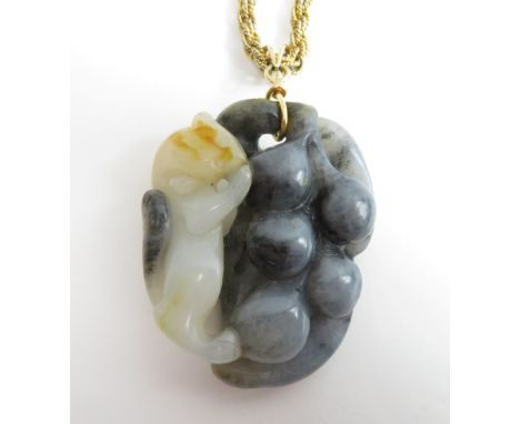 A two colour carved jade pendant, of a squirrel and berries, the bale stamped '585' and '14K', the jade approximately 5.5 cm 