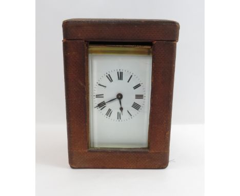 A French carriage clock, with a white enamelled dial, Roman numerals in a leather carry case