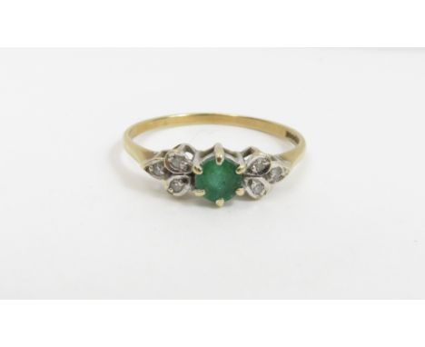 An emerald and diamond 9 carat gold ring, the round cut stone with a trio of single cuts to each shoulder, finger size M1/2, 