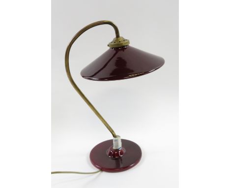 A French 20th century glass and red enamel bedside light, with a shaped brass arm on a circular base, 54cm high