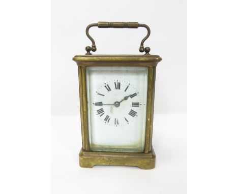A brass cased travelling timepiece having white enamel dial, black Roman numerals and with French movement 11.5cm high