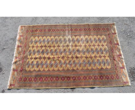 A Tekke rug the central field with three rows of medallions within narrow guard stripes and wider border, orange/red/blue on 