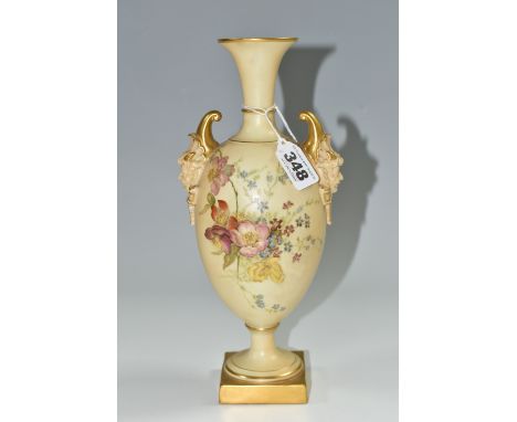 A ROYAL WORCESTER VASE WITH MASK BOSS HANDLES, a collared flared neck vase in a blush ivory ground with hand painted flower d