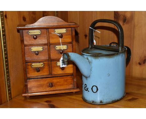 A SMALL SPICE CABINET AND A BLUE ENAMEL HOT WATER POT, comprising a seven drawer spice cabinet, six smaller drawers above one