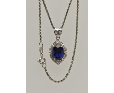 A WHITE METAL PENDANT NECKLACE, the pendant set with an oval cut synthetic blue sapphire in a surround of colourless cubic zi