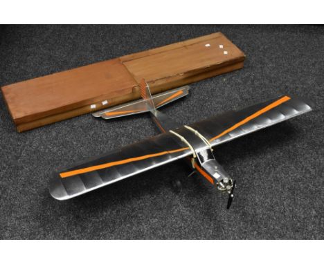 A Radio controlled balsa wood and paper single wing Aeroplane, silver fuselage and wings, orange detailing, petrol engine, Hi