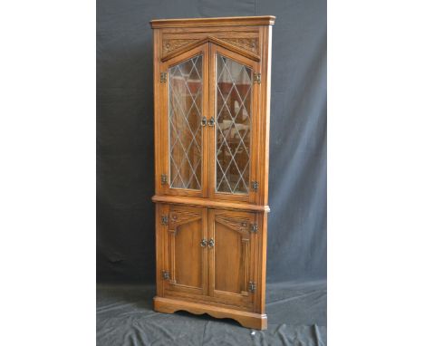 An oak floor standing corner cabinet with glazed leaded light