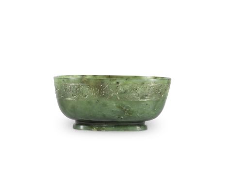 An engraved jade bowl Persia, probably 18th/ 19th Centuryof deep elongated form on a short splayed foot, engraved to the side