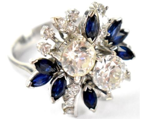 A good white metal diamond and sapphire floral ring, the twin principal round brilliant cut stones each weighing approx 1ct, 