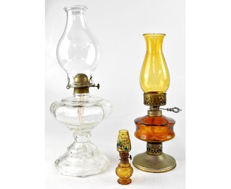 Three varying size oil lamps to include a pressed clear glass example with octagonal oil reservoir to stepped octagonal base,
