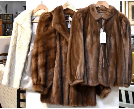 Three vintage c1950s mink jackets comprising an ivory three-quarter length jacket with stand-up collar, a dark blonde mink wi