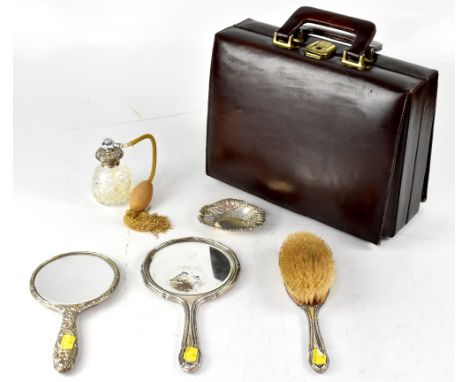 A hallmarked silver filled dressing table hand mirror with repoussé decoration of scrolls, shields, birds and mask to the fro