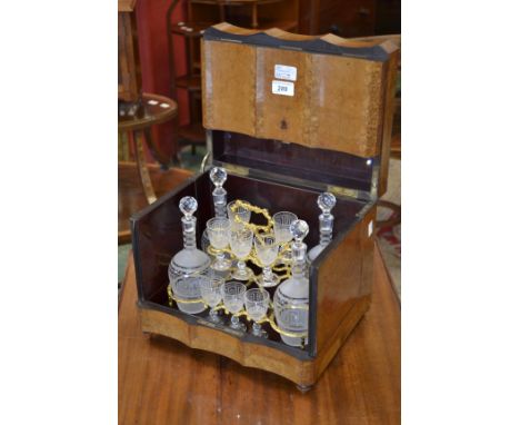 A 19th century French crossbanded walnut commode shaped decanter box, hinged cover and front enclosing a gilt metal liquor wa