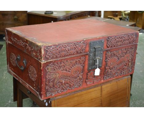 A Chinese red lacquered rectangular travelling trunk or document box, hinged cover, brass hasp, the front decorated in relief
