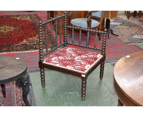 A 19th century corner chair, bobbin turned top rails and supports, padded seat.