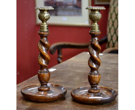 A pair of oak candlestick with ornate brass sconces
