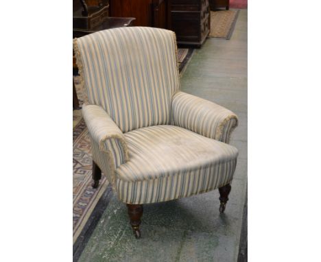 A Victorian walnut armchair, in the manner of  Howard & Sons, stuffed-over upholstery, turned legs, ceramic casters, 82cm wid