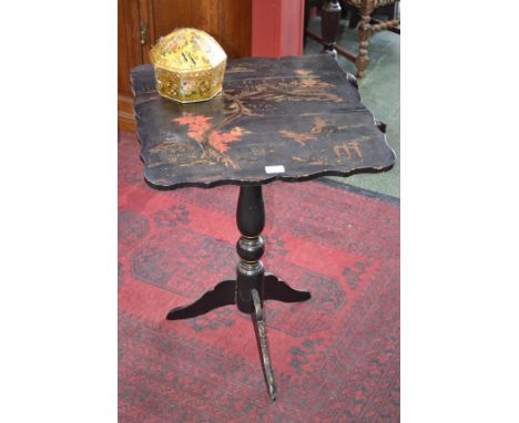 An early 20th century Japonesque black lacquer tripod table, applied with a landscape and figures, shaped square tilt top, 72