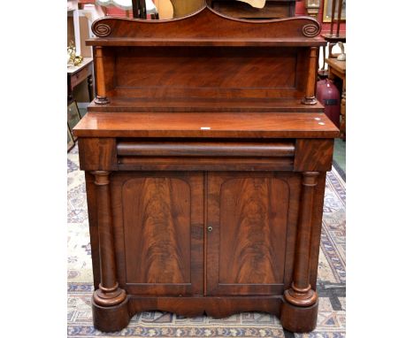 A William IV flame mahogany chiffonier, shaped pediment and shelf , tapering cylindrical supports, long drawer over two door 