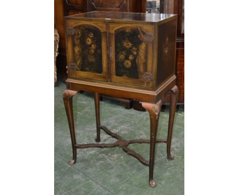 An 18th century style painted cabinet on stand, flush top above a pair of rectangular doors decorated with flowers in a niche