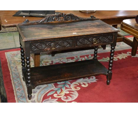 A 19th century oak hall table, carved gallery, moulded top, two short carved front drawers, brass loop handles, bobbin turned