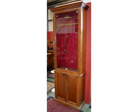 An Edwardian oak gun cabinet, made by Army and Navy CSL (Co-operative Society Limited), glazed panel door, lined with red vel