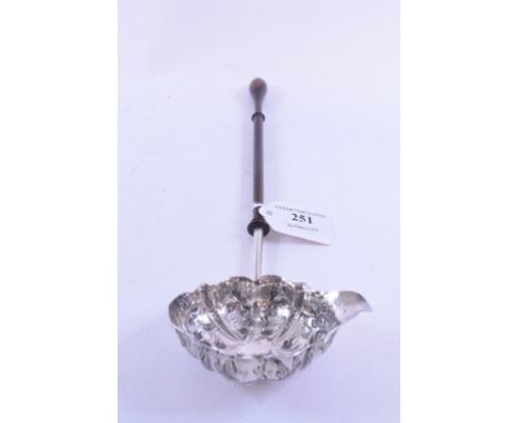 A late 18th century punch/toddy ladle, the silver bowl embossed flowers and foliage, on a lignum vitae turned wood handle, Lo