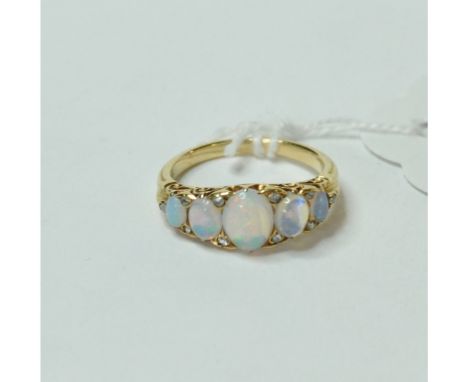 A five stone opal ring, the opals indispersed with diamond chips, in a yellow coloured metal mount, approx. ring size M½   Co