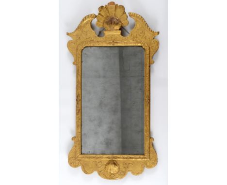 An early 18th century parcel gilt wall mirror, the architectural top with a shell and feather surmount, 97 x 51 cm  See illus
