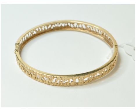 A 9ct gold textured bangle, with pierced decoration, approx. 17.2g