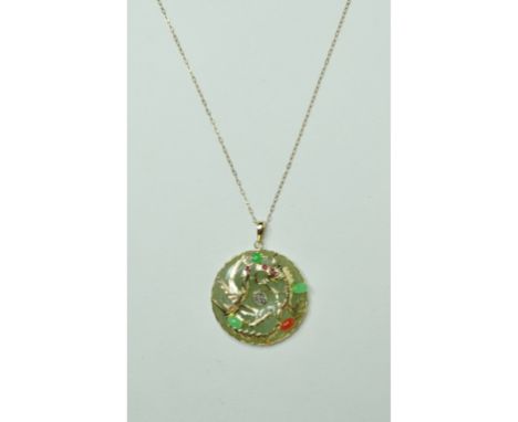 A 14ct gold and jade pendant, decorated dragons and set gem stones, on a 9ct gold chain