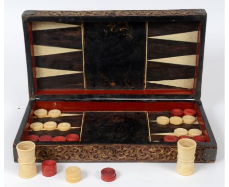 An 18th/19th century Chinese backgammon set, with turned and carved red stained and natural ivory counters, leather and turne