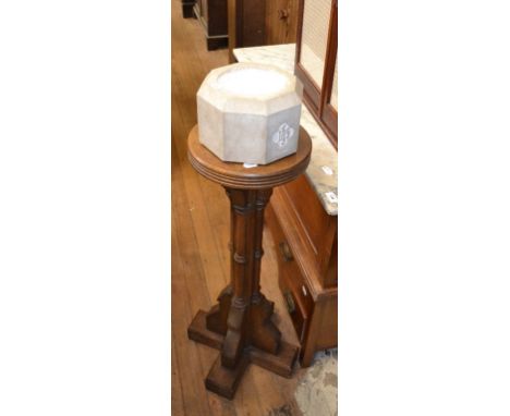 An Arts and Crafts style carved oak and composition font, 108 cm high, an easel/folio stand, four wrought iron plant stands a