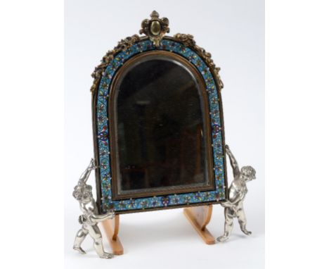 A gilt metal and champlevé enamel mirror, the arched frame supported by two silvered putti, 34.5 cm high  See illustration 
