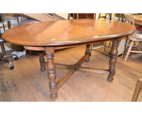 An Ercol extending elm dining table, 163 cm wide, with one extra leaf, a set of eight matching chairs, and an Ercol rocking c