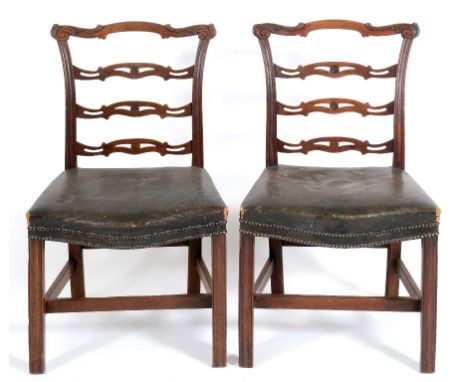 A set of four George III mahogany ladder back dining chairs, with leather upholstered seats, and chamfered square front legs,
