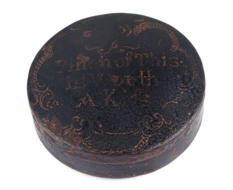 A Regency toleware compressed circular snuff box decorated with a motto 'A Pinch of This is Worth a Kiss', 6cms diameter.