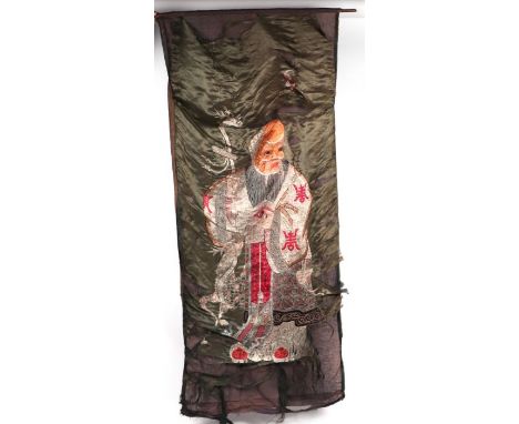A Chinese silk embroidered wall hanging panel depicting a sage with a serpent staff, approx 155 by 68cms; together with anoth