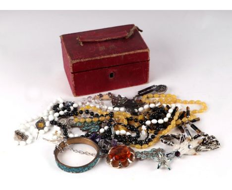 A quantity of costume jewellery in a red leather jewellery box.