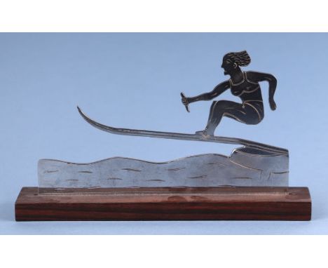 An Art Deco chrome sculpture depicting a female water skier, signed 'Yie', mounted on a rosewood plinth, 22cms wide.Condition