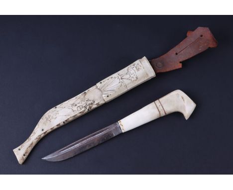 An Inuit dagger with bone handle and scabbard decorated with a reindeer, 25cms long.