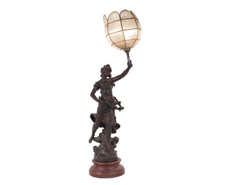 A spelter figural lamp in the form of a maiden holding a torch aloft, mounted on a wooden base, 72cms high.