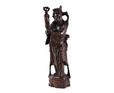 A Chinese carved hardwood figure depicting a wise man holding an urn, with silver wire inlaid decoration, 41.5cms high.Condit