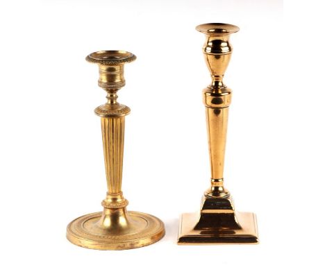 A brass candlestick in the Adam taste, 21cms high; together with another similar, 19cms high (2).