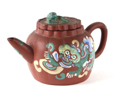 A Chinese Yixing teapot decorated with enamelled dogs of fo, 11cms high.