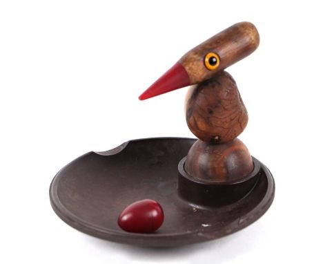 An At Deco Bakelite and carved walnut ashtray with bird with amber type beak and glass eyes; and a loose amber type nut, 14cm